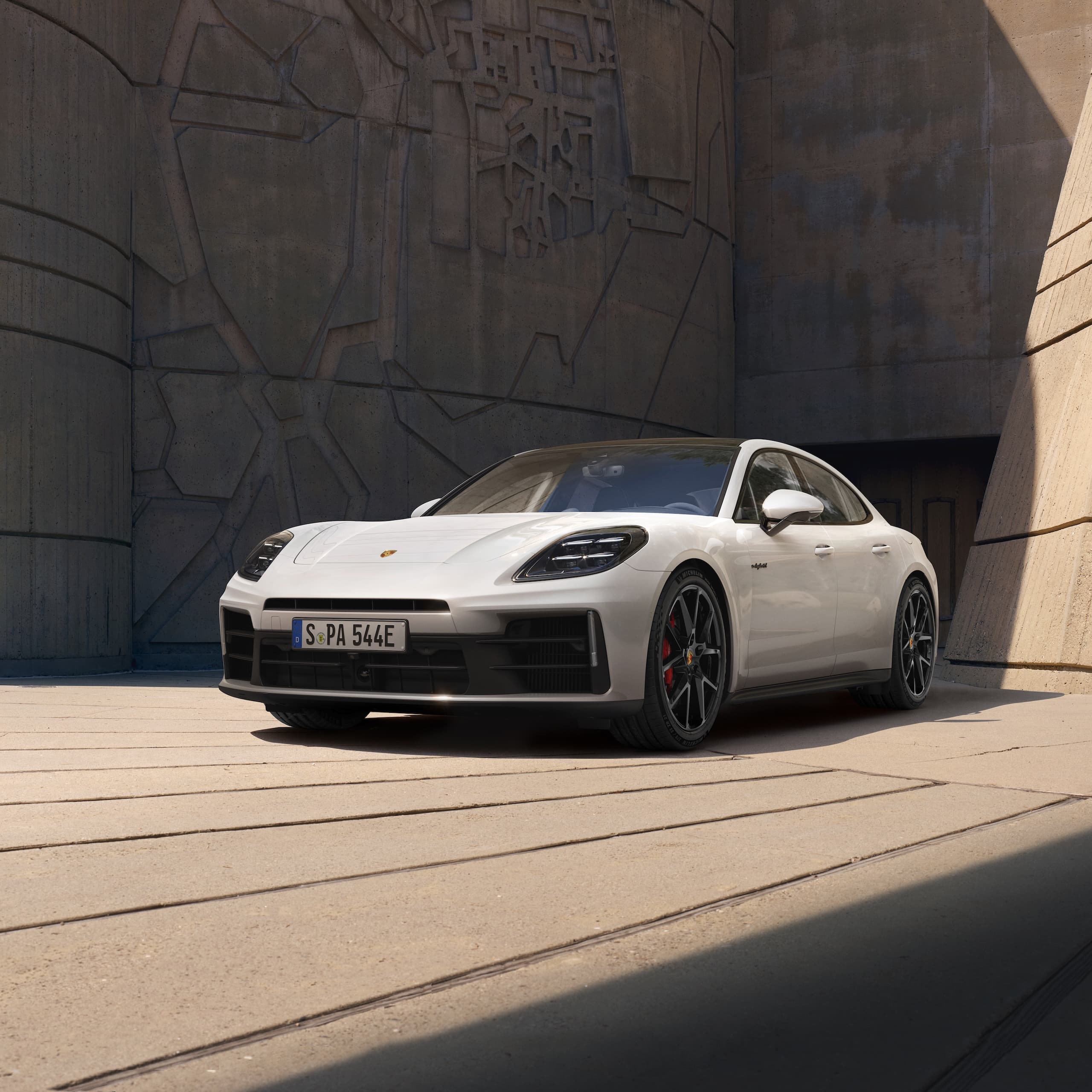 Una Porsche Panamera parcheggiata davanti a un edificio moderno.